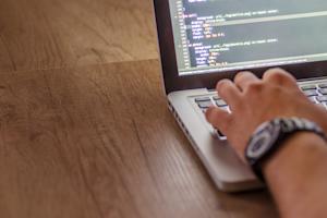 A laptop screen with code being typed on it.