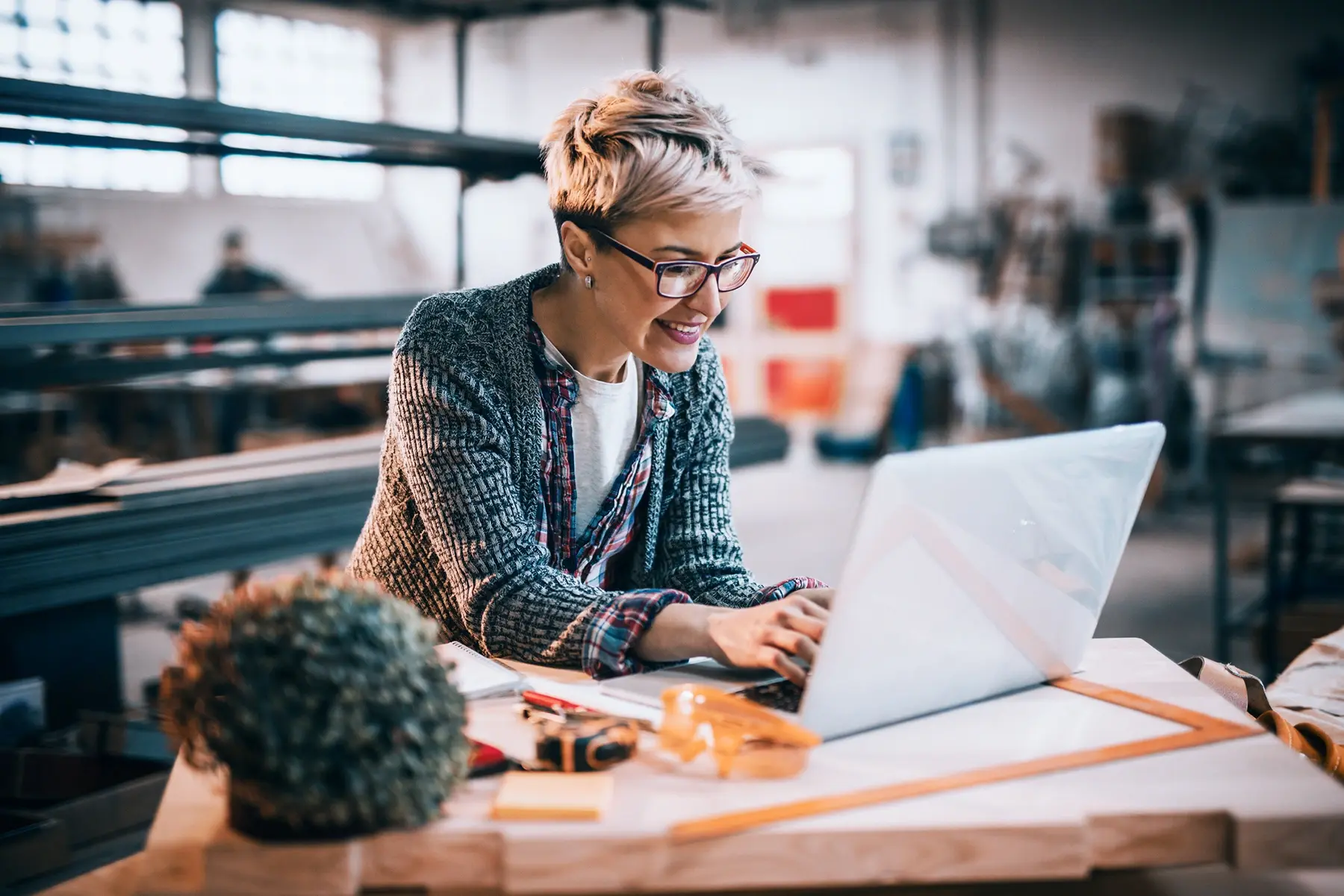 A young woman working on her laptop in a creative studio