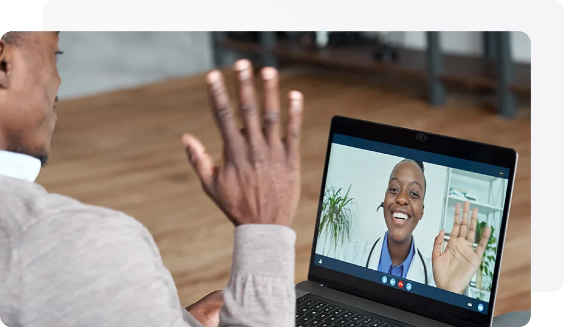 A man waving to a physician on screen