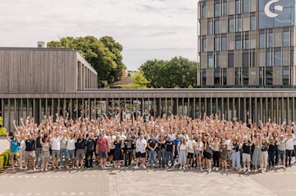 All shopware employees standing on the campus, cheering and raising their hands in the air.