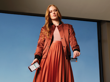 Woman wearing a red dress and holding a mobile.