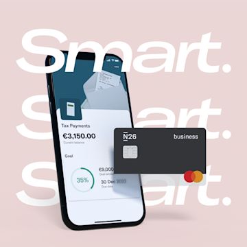 Image of a mobile phone showing a subaccount on the screen and a black busimness N26 debit card in the side.