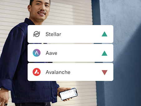 Person walking in the background. In the foreground there is a pop up displaying Stellar, Aave, and Avalanche crypto coins.